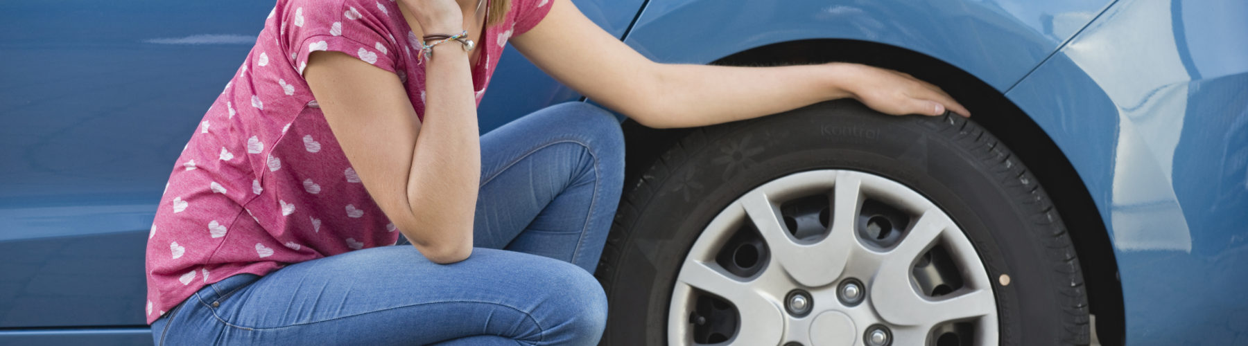 Woman With Flat Tyre On Car Phoning For Assistance Woman With Flat Tyre On Car Phoning For Assistance